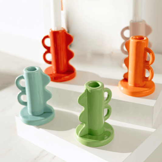 Colorful ceramic candle holders on a white surface