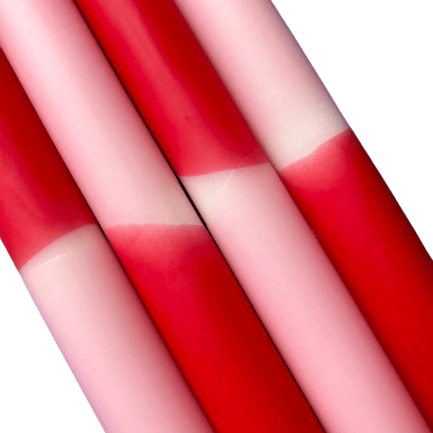 Close-up of red and pink striped candles on a white background